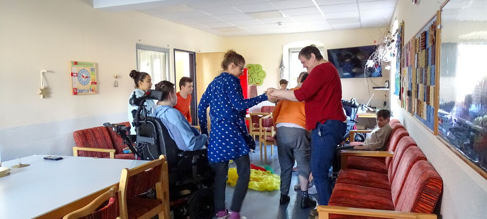 Auf dem Bild tanzen Pfleger und Klienten zur Musik.