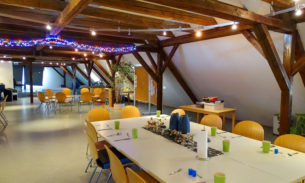 Ein Bild vom Aufenthaltsraum im Josephhaus. Auf dem Bild sind die Tische mit Besteck und Bechern gedeckt.