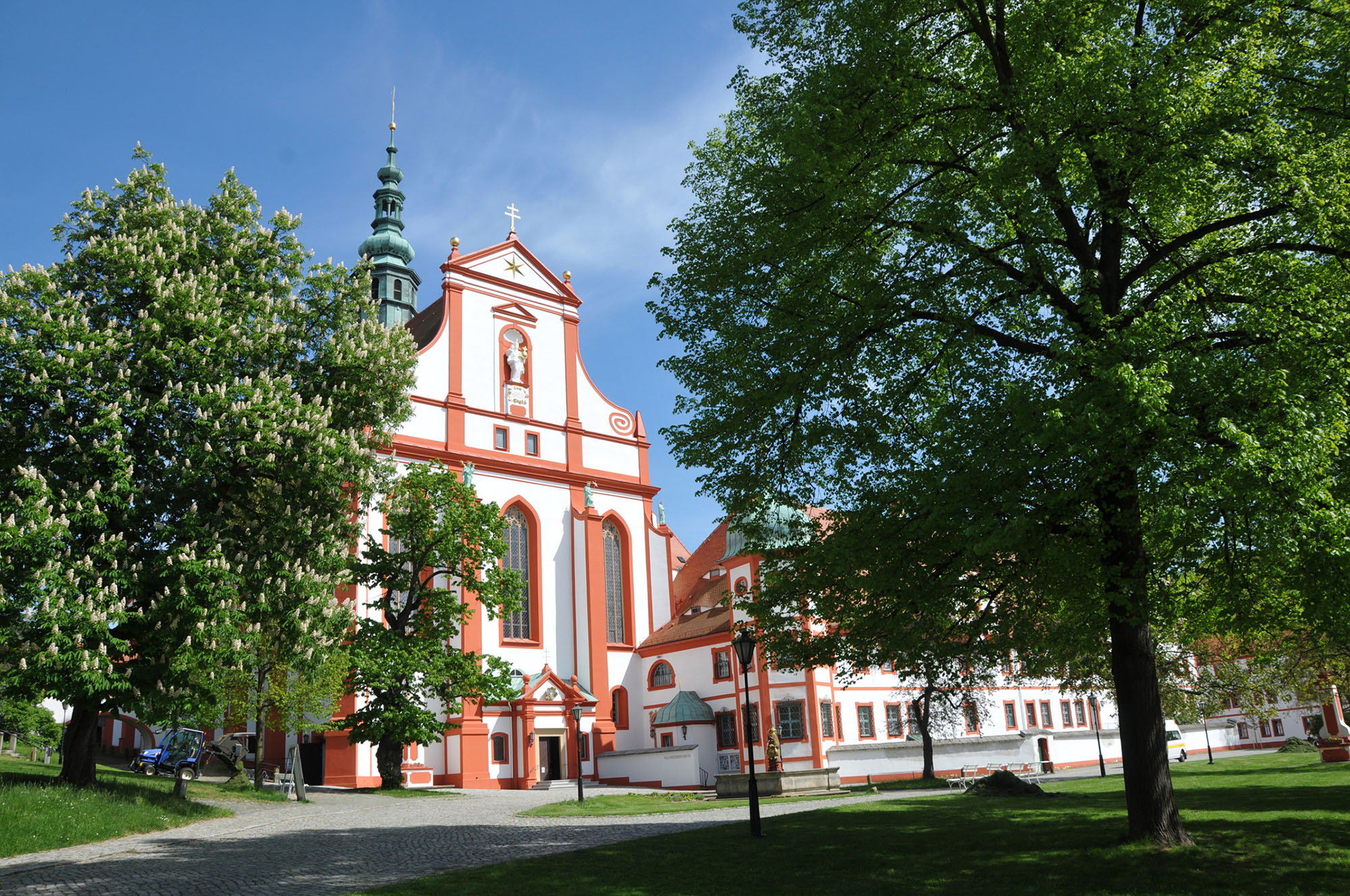 Ein Blick in den Klosterhof mit der Klosterkirche und grünen Bäumen im Hintergrund.